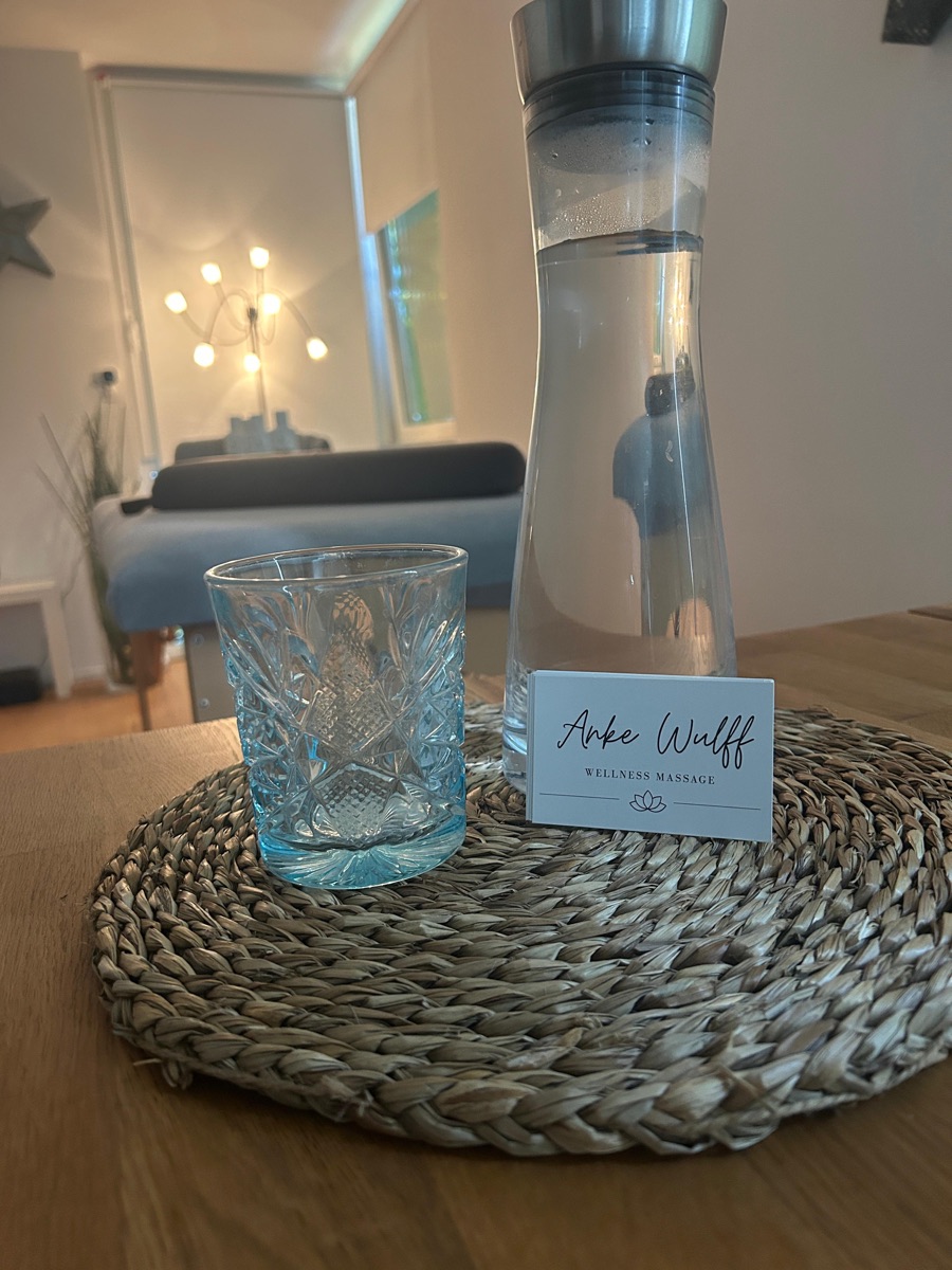 Wasserkaraffe und Glas mit Visitenkarte
